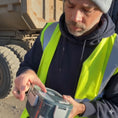 Load image into Gallery viewer, Man in a high-visibility vest holding a electric lunch box outdoors with a truck in the background
